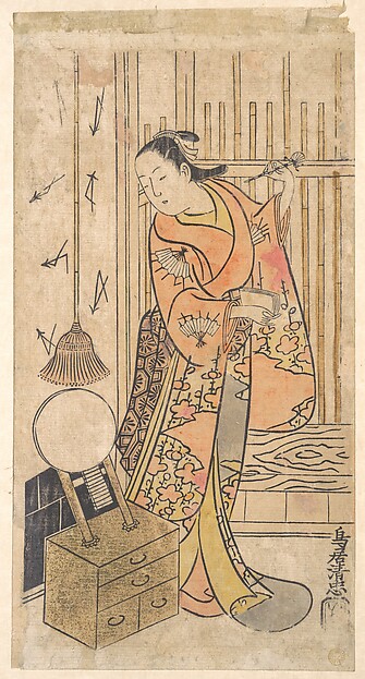 鏡台のそばに立つ女に扮する役者